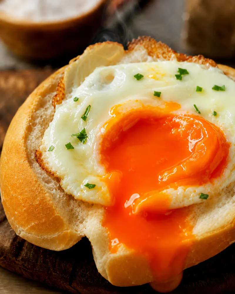 Ovo com gema alaranjada sobre pão fresco